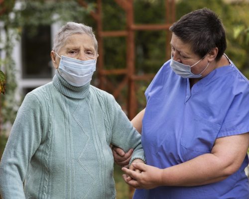 female-nurse-taking-care-older-woman-with-medical-mask